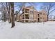 Angled exterior view of a brown condo building with balconies surrounded by snow-covered ground at 10950 W Florida Ave # 303, Lakewood, CO 80232