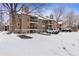 Exterior angle of a brown condo building with balconies and snow-covered parking lot at 10950 W Florida Ave # 303, Lakewood, CO 80232