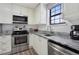 White kitchen features gray granite countertops and stainless steel appliances at 10950 W Florida Ave # 303, Lakewood, CO 80232