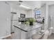 Bright kitchen features stainless steel appliances, white cabinets and an island with a granite countertop and two chairs at 10950 W Florida Ave # 303, Lakewood, CO 80232