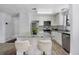 Well-lit kitchen featuring white cabinetry, stainless steel appliances, and a gray granite countertop island with seating at 10950 W Florida Ave # 303, Lakewood, CO 80232