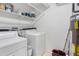 Bright Laundry Room features a white washer, dryer, and shelves for storage at 10950 W Florida Ave # 303, Lakewood, CO 80232