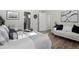 This bedroom features a bright open doorway, hardwood floors and a view of a sleek, modern bathroom at 1996 W 66Th Ave, Denver, CO 80221