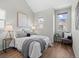This bedroom boasts wood floors, neutral decor, a cozy chair and natural light from three windows at 1996 W 66Th Ave, Denver, CO 80221