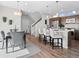 Open dining area with bar stool seating at kitchen island, modern light fixtures, and hardwood floors at 1996 W 66Th Ave, Denver, CO 80221