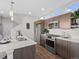 Modern kitchen with stainless steel appliances, quartz countertops, and dark wood cabinets at 1996 W 66Th Ave, Denver, CO 80221