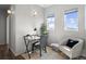 This office features a desk, chair, side chair with dark blue pillow, and two windows for lots of light at 1996 W 66Th Ave, Denver, CO 80221