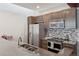 Kitchen featuring stainless steel appliances, tile backsplash, and concrete countertops at 3100 Huron St # 4Q, Denver, CO 80202