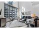 Modern living room boasts large windows, comfortable seating, and industrial decor at 3100 Huron St # 4Q, Denver, CO 80202