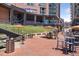 Outdoor seating area with cafe tables, umbrellas, and views of the stadium, offering a relaxing atmosphere at 3100 Huron St # 4Q, Denver, CO 80202