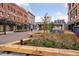 Inviting plaza with modern benches, green spaces, and views of the city skyline and pedestrian bridge at 3100 Huron St # 4Q, Denver, CO 80202