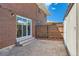Backyard featuring brick exterior, sliding glass doors and stone patio at 9263 E Nassau Ave, Denver, CO 80237
