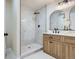 Modern bathroom features white and gray marble shower and light wood vanity at 9263 E Nassau Ave, Denver, CO 80237