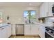 Bright kitchen featuring white countertops and cabinets, accented with modern gold hardware at 9263 E Nassau Ave, Denver, CO 80237