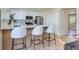 Modern kitchen with a breakfast bar, white cabinets, and stainless steel appliances at 9263 E Nassau Ave, Denver, CO 80237