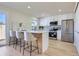 Contemporary kitchen with white cabinets, stainless steel appliances, and a breakfast bar at 9263 E Nassau Ave, Denver, CO 80237