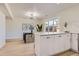 Bright kitchen features an island, white cabinets, light wood floors, and dining area at 9263 E Nassau Ave, Denver, CO 80237