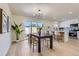 View of kitchen and dining area with light wood floors and sliding glass door at 9263 E Nassau Ave, Denver, CO 80237