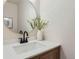 Powder room with stylish mirror, wooden vanity, white countertop, and modern black faucet at 9263 E Nassau Ave, Denver, CO 80237