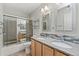 Bathroom with double vanity, decorative mirrors, tiled backsplash, toilet, and shower with glass doors at 4195 W 111Th Cir, Westminster, CO 80031