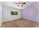 Bedroom with large window, ceiling fan and neutral carpeting and a purple accent wall at 4195 W 111Th Cir, Westminster, CO 80031