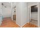 Hallway with hardwood flooring, neutral paint, and a view of a laundry room with cabinets at 4195 W 111Th Cir, Westminster, CO 80031