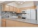 Kitchen with granite countertops, tile backsplash, white appliances, and farmhouse sink at 4195 W 111Th Cir, Westminster, CO 80031