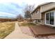 This home features a spacious backyard, a wooden deck, a walkway, and mature trees at 4653 S Yank St, Morrison, CO 80465