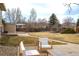 Spacious backyard with a concrete patio, green lawn, and mature trees offering privacy and space at 4653 S Yank St, Morrison, CO 80465