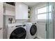 This laundry room is equipped with a washer and dryer, cabinets, and shelves for storage at 4653 S Yank St, Morrison, CO 80465