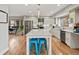 Open-concept kitchen featuring a large island with seating, stainless steel appliances, and hardwood floors at 1123 E 132Nd Way, Thornton, CO 80241