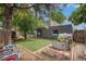 Cozy backyard featuring lush lawn, garden beds, mature trees, and a charming swing set for outdoor enjoyment at 14753 E Alabama Pl, Aurora, CO 80012