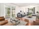 Bright living room featuring hardwood floors, a modern sofa, and sliding doors to a covered patio at 14753 E Alabama Pl, Aurora, CO 80012