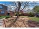 Landscaped backyard featuring a large tree, wood mulch, and brick borders at 2285 N Monaco Pkwy, Denver, CO 80207