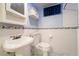 The blue and white bathroom features tile floors, a pedestal sink and a toilet at 2285 N Monaco Pkwy, Denver, CO 80207
