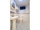 The tiled bathroom features tile floors, a pedestal sink and a toilet at 2285 N Monaco Pkwy, Denver, CO 80207