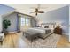 Bedroom with a large bed, area rug, ceiling fan and window with floral curtains at 2285 N Monaco Pkwy, Denver, CO 80207