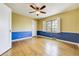 This spacious bedroom features hardwood floors, complemented by a ceiling fan, and natural light at 2285 N Monaco Pkwy, Denver, CO 80207