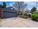 Detached two-car garage with concrete driveway and fenced yard with mature trees at 2285 N Monaco Pkwy, Denver, CO 80207