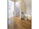 Hallway with hardwood floors that offers access to bathroom and staircase to basement at 2285 N Monaco Pkwy, Denver, CO 80207