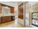 Practical kitchen area with wood cabinets, sleek black appliances, and convenient access to entryway at 2285 N Monaco Pkwy, Denver, CO 80207