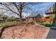 Backyard with brick patio and detached garage surrounded by mature trees and landscaping at 2285 N Monaco Pkwy, Denver, CO 80207