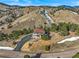 Expansive aerial view of a home nestled within a densely treed area with a long driveway at 457 Buena Vista Rd, Golden, CO 80401