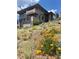 Beautiful home with stone accents, a front balcony, and a well-manicured hillside garden at 457 Buena Vista Rd, Golden, CO 80401