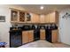 Basement wet bar with wood cabinets, granite countertops, and wine rack at 7857 Allison Ct, Arvada, CO 80005