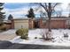 Brick ranch home with attached garage, landscaping, and snow-covered yard at 7857 Allison Ct, Arvada, CO 80005