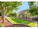 The backyard features a well-manicured lawn, a deck, solar panels, and lush trees for privacy at 7420 S Houstoun Waring Cir, Littleton, CO 80120