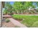 A sprawling backyard features a brick path, lush lawn, garden beds, and a wooden deck, perfect for outdoor enjoyment at 7420 S Houstoun Waring Cir, Littleton, CO 80120