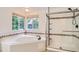 Bright bathroom featuring a corner tub, a glass-enclosed shower, and tiled accents at 7420 S Houstoun Waring Cir, Littleton, CO 80120