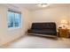 Bedroom with a large window and a futon couch, perfect for guests or a home office at 7420 S Houstoun Waring Cir, Littleton, CO 80120